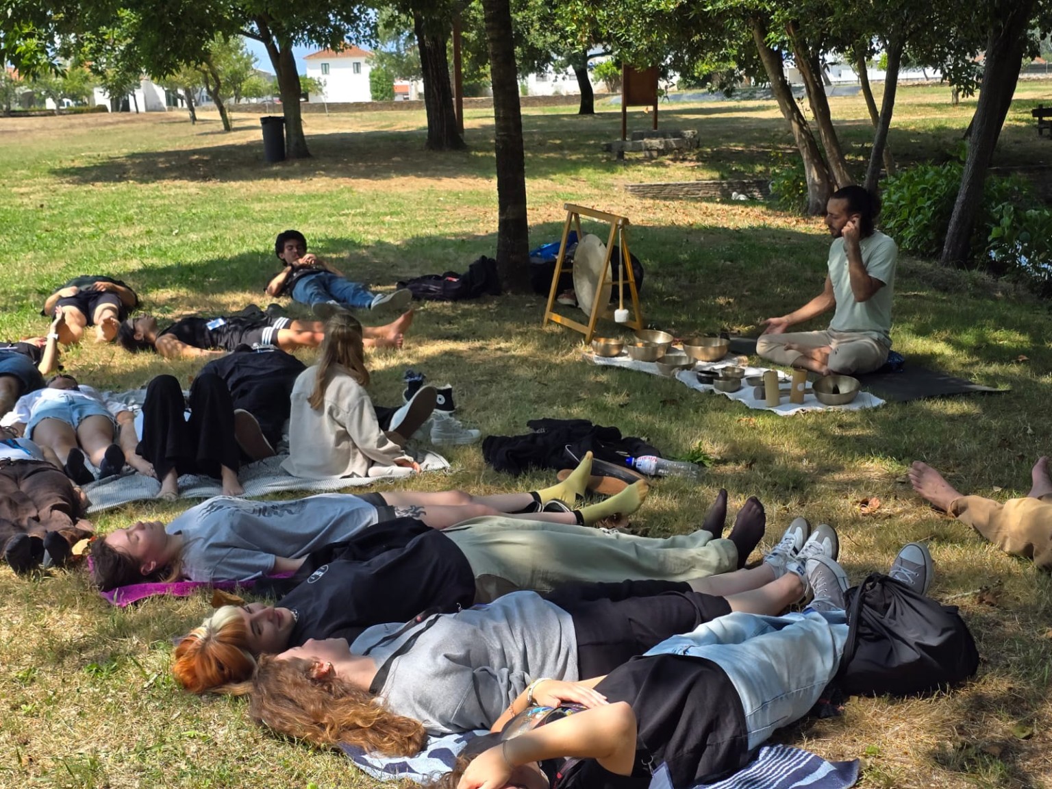 Participantes deitados durante o concerto de som ao ar livre no encontro Erasmus